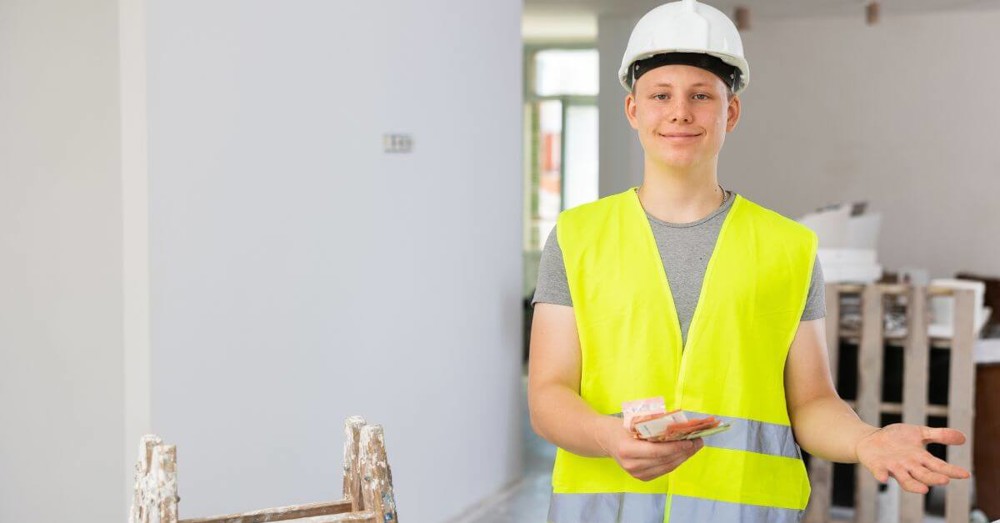 Young person wearing a hi vis vest and hard hat