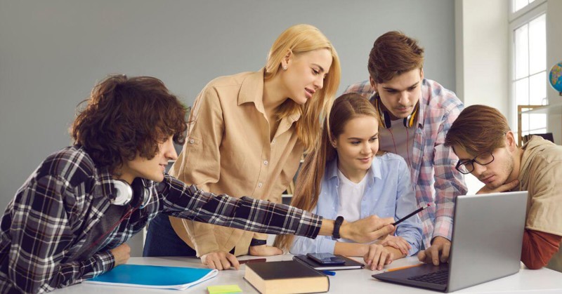 Group of young people looking at a laptop