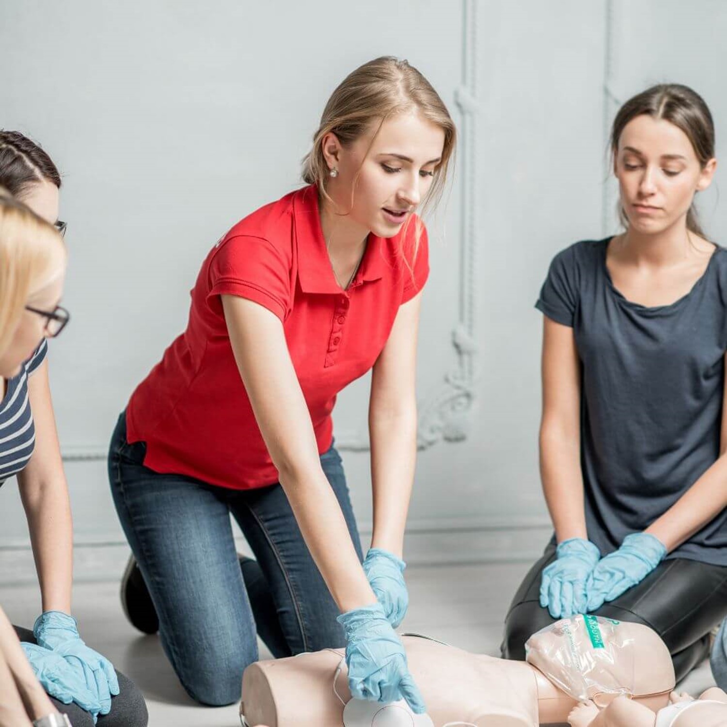 Group of people looking at a first aid dummy