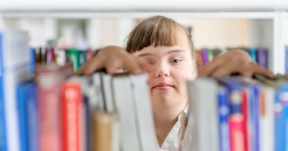 Young person putting books on a shelf